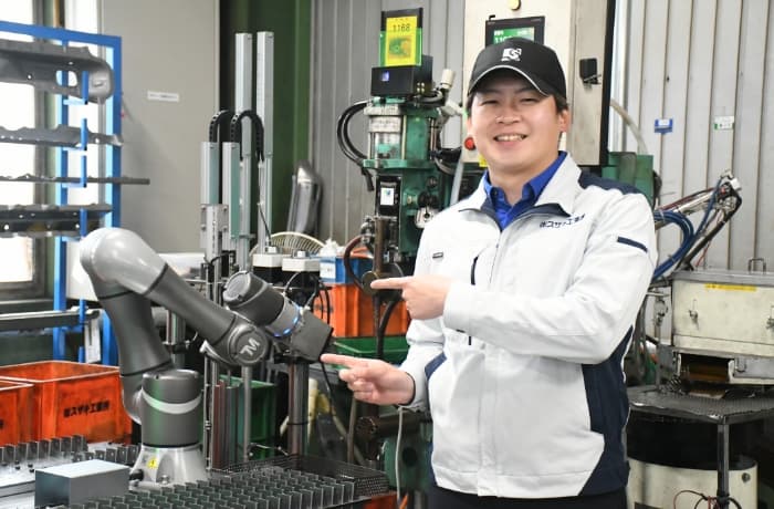 スポット溶接機に部品を供給する協働ロボットシステムと鷲﨑圭一朗取締役のイメージ